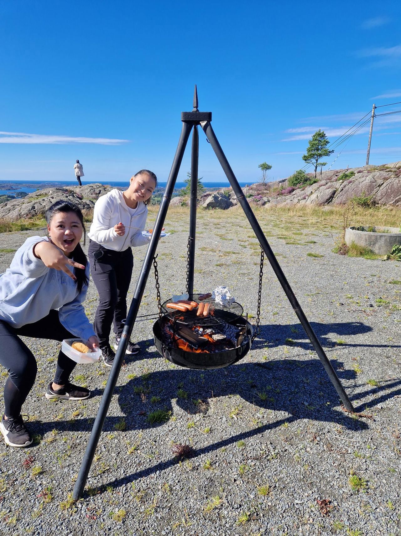 To elevar grillar pølser på ein grill