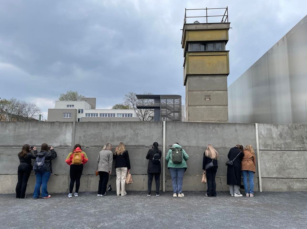 Elevane står med ansiktet mot ein mur og kikkar gjennom ei sprekke